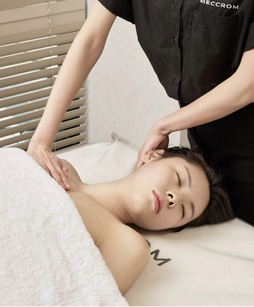 A Meccrom therapist providing gentle neck and shoulder care in a private treatment room